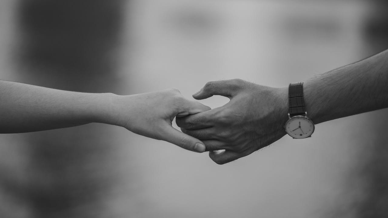 our-services-3 Monochrome image of two hands holding, symbolizing love and connection.