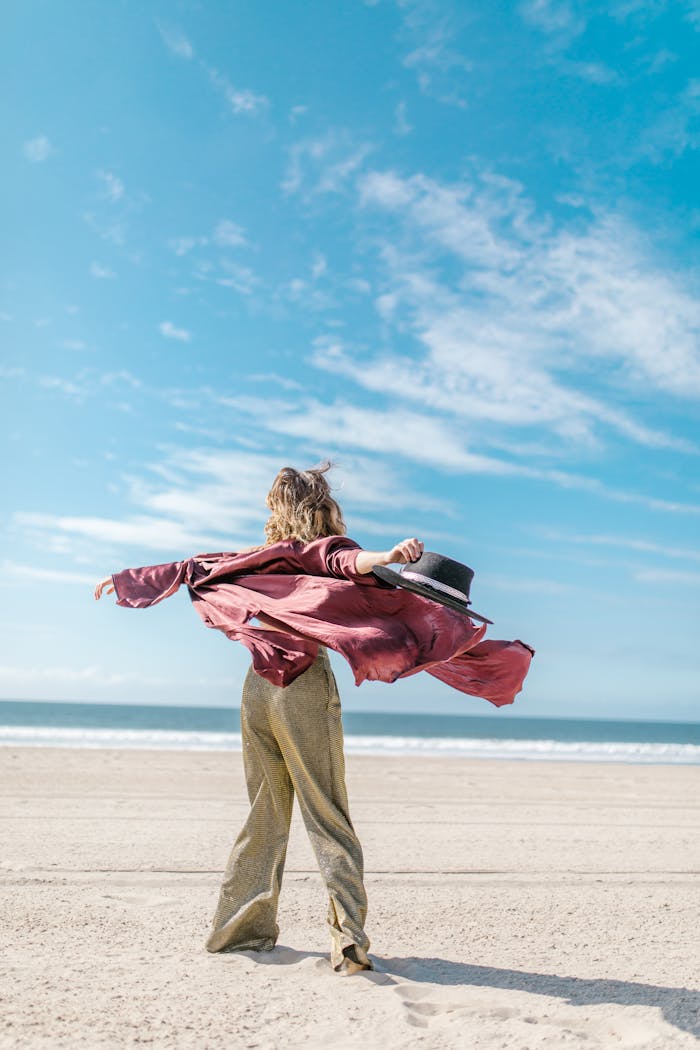 about-01 A joyful person embracing the freedom of a sunny day at the beach, symbolizing adventure and relaxation.